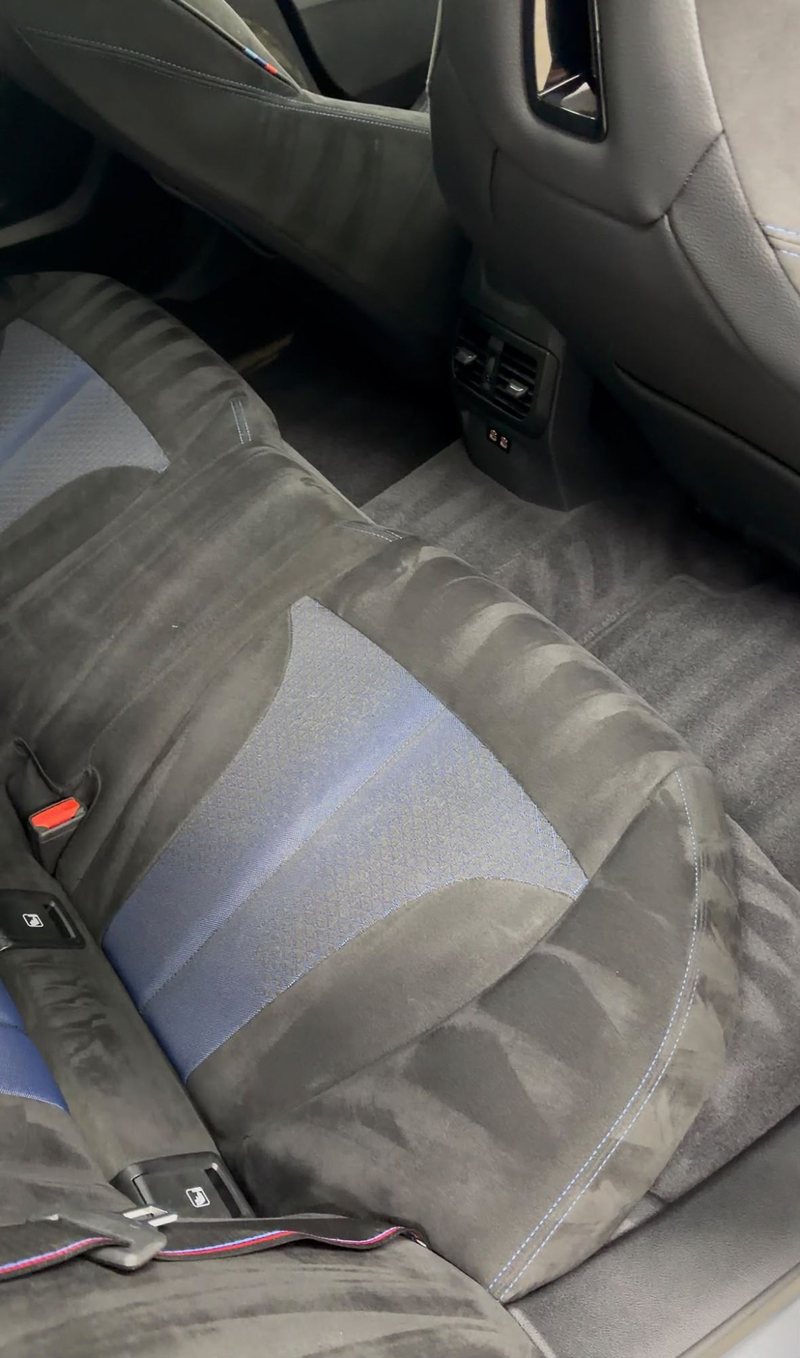 Gereinigde alcantara achterbank van een BMW M na interieur detailing bij JS Detail Studio in IJmuiden