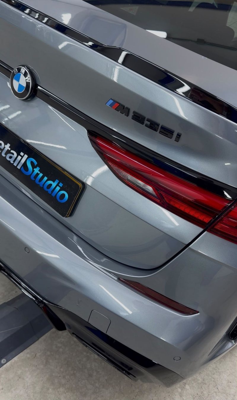 Achterzijde van een grijze BMW M235i met hoogglans gepolijste lak na exterieur detailing bij JS Detail Studio in IJmuiden