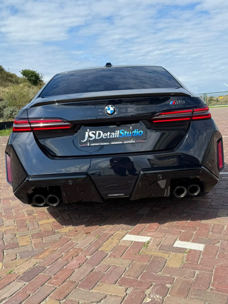 Zwarte BMW M5 achterzijde met JS Detail Studio kentekenplaat na exterieur detailing in IJmuiden