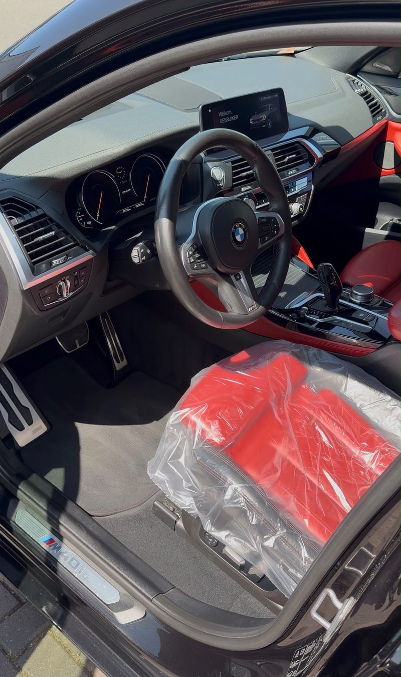 Interieur van een BMW X4 M40i met rood leer en M-sportstuur na interieur detailing bij JS Detail Studio in IJmuiden