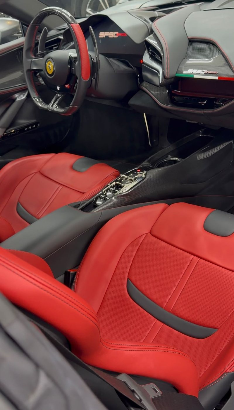 Rood lederen interieur met carbon middenconsole van een Ferrari SF90 Spider na interieur detailing bij JS Detail Studio in IJmuiden