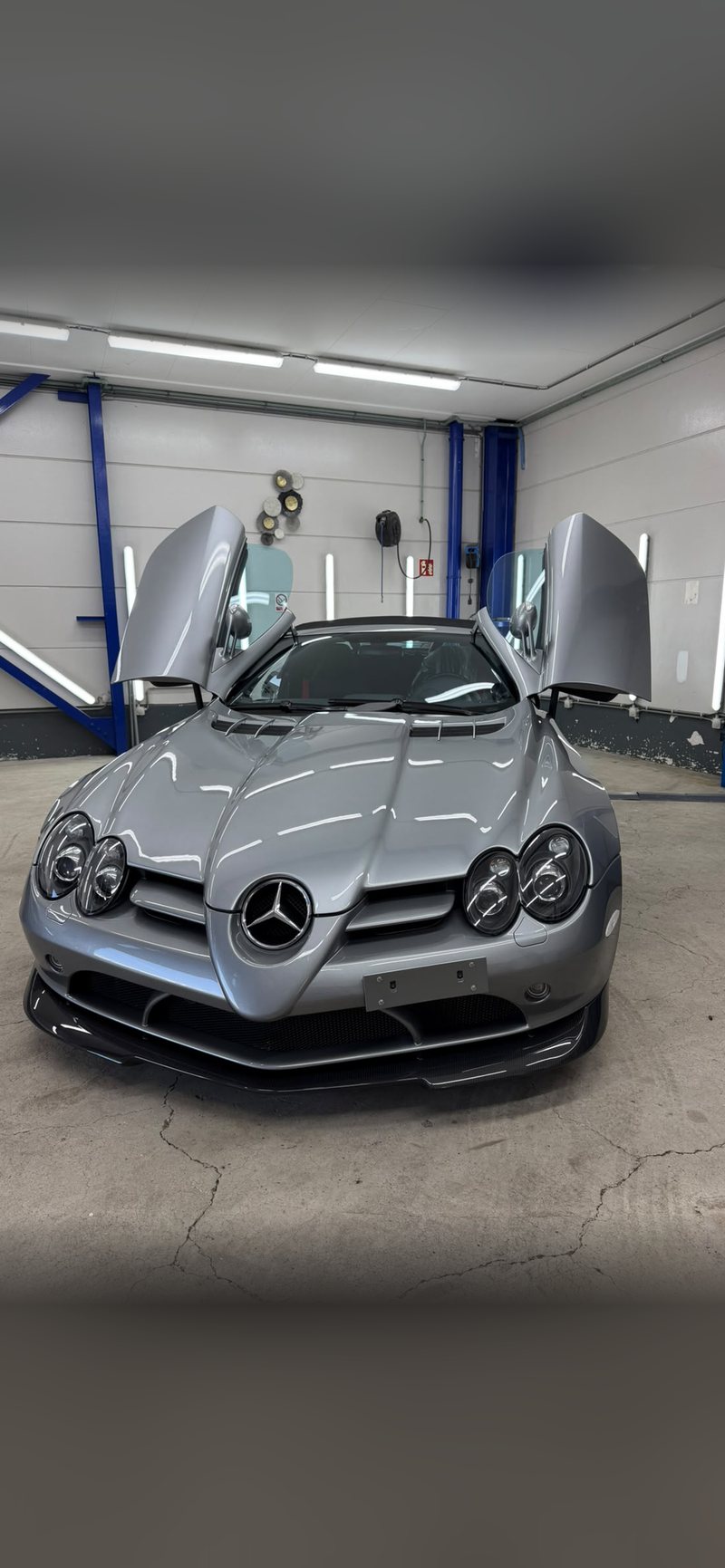 Zilvergrijze Mercedes SLR McLaren met geopende vlinderdeuren in de detailingstudio van JS Detail Studio in IJmuiden