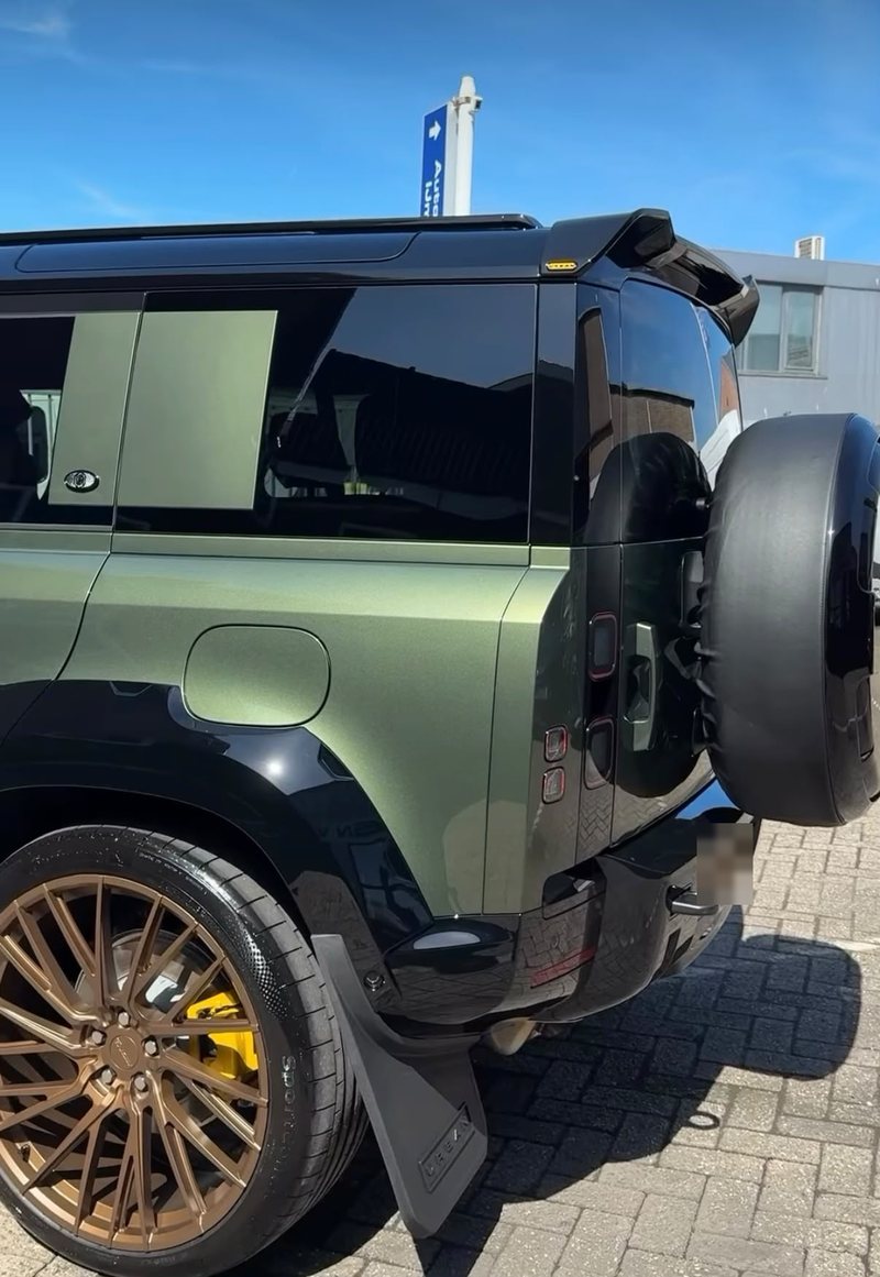 Achterzijde van een groene Land Rover Defender met bronzen velgen na exterieur detailing bij JS Detail Studio in IJmuiden