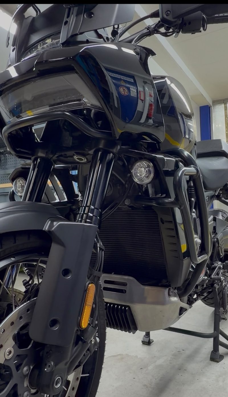 Voorzijde van een zwarte toermotor met gereinigde vork en beugels na detailing bij JS Detail Studio