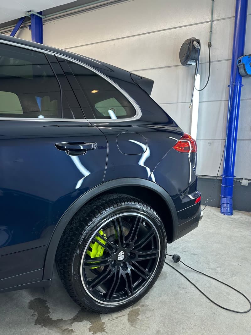 Donkerblauwe Porsche Cayenne met hoogglans lak na exterieur detailing